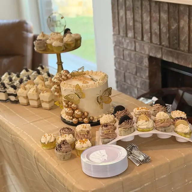 Full celebration dessert table in gold and cream