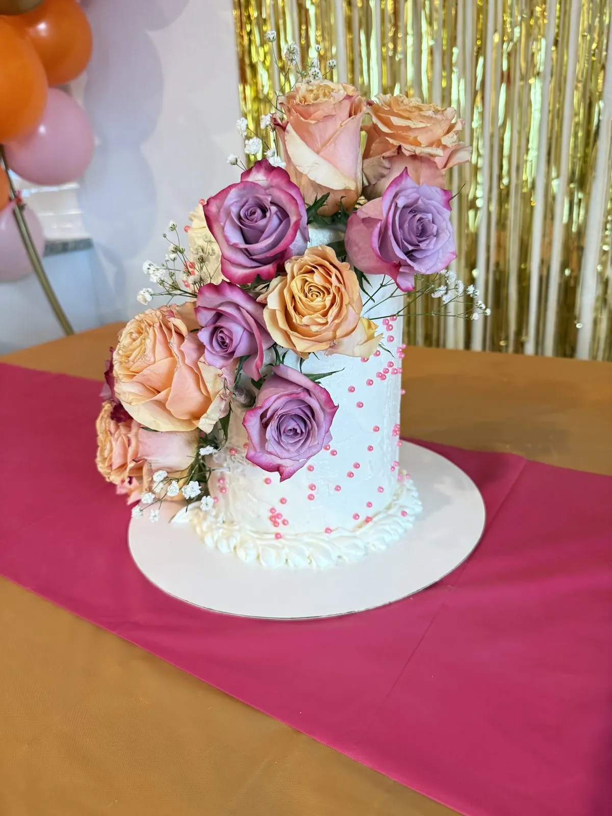 Whisked and Sugared — white cake with fresh roses at a celebration